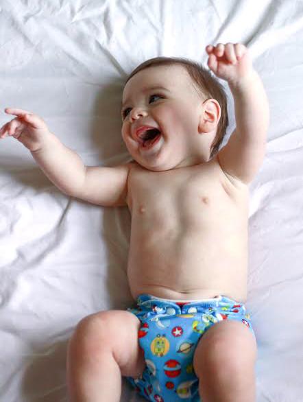 Noah laying on a sheet in a Charlie Banana Reusable Cloth Diaper