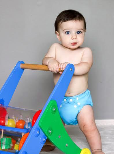 Noah pushing a toy in a blue Charlie Banana Reusable Cloth Diaper
