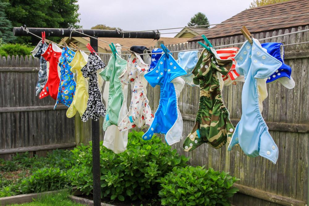 Brightly colored Charlie Banana Reusable Cloth Diapers drying on a clothes line