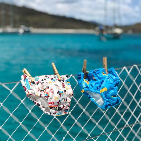 Two Charlie Banana Swim Diapers drying on a fence